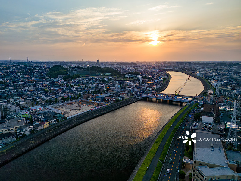 正在进行主要桥梁更换工程。日落倒映在河面上。一座横跨河流的桥梁。鹤见川的无人机镜头。西边是横滨市的鹤见区；东边是川崎市的川崎区和幸区。图片素材