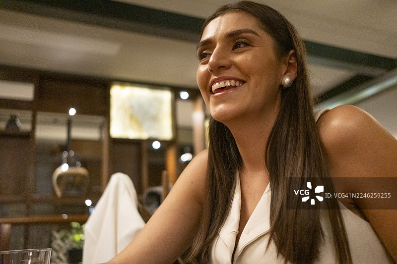 一位年轻女子在舒适优雅的氛围中参加晚宴图片素材