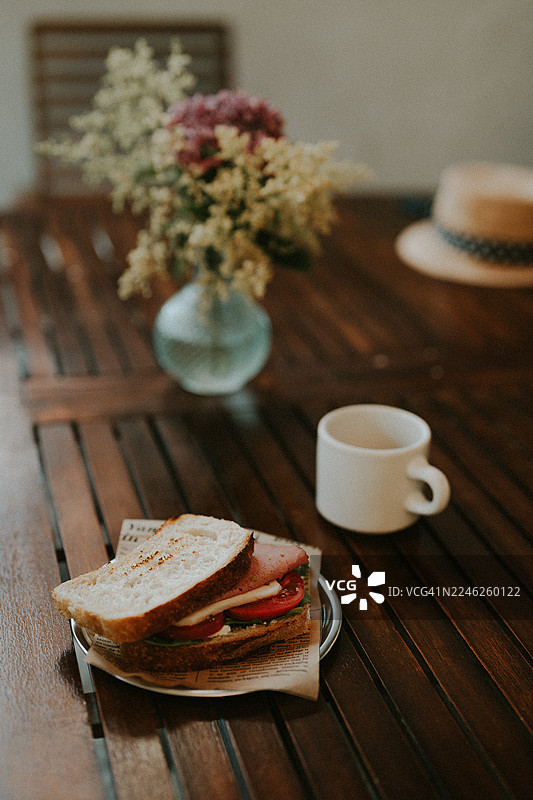 新鲜的手工三明治，配有番茄、切达奶酪和蔬菜，放在木桌上图片素材