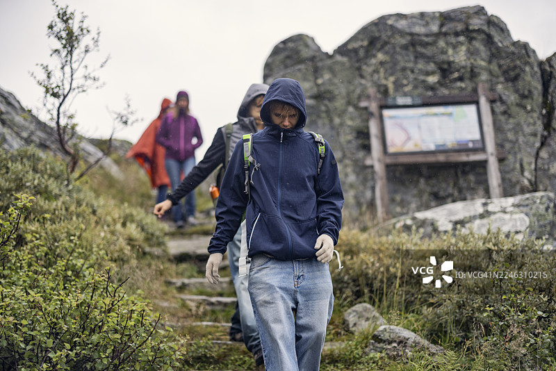 徒步者在阴天走在僧侣步道（Munketrappene）湿滑的石阶上。图片素材