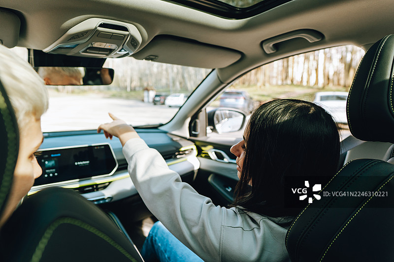 女性朋友们在公路旅行中，指着地图寻找路线图片素材