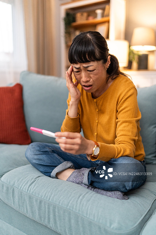 焦虑的女性面对意外的怀孕检测阳性结果图片素材