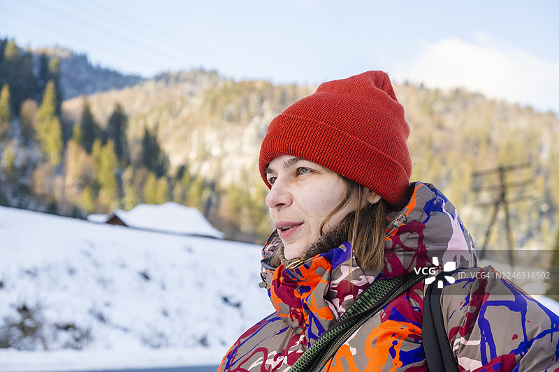 戴着红色绒线帽的女性享受冬季山景图片素材