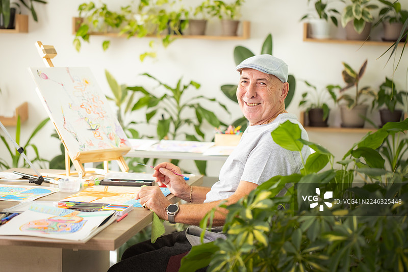 资深插画师在充满植物的工作室里绘画图片素材