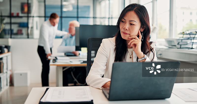 一名女子在办公室使用笔记本电脑进行法律研究，她在思考，并计划着案件。她是一名律师，正在网上查找数字证据。图片素材