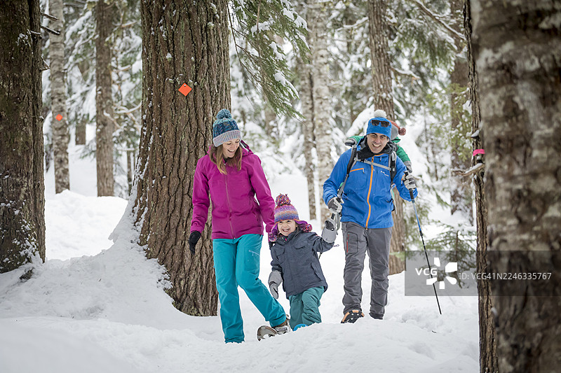 一家人在雪地里穿行于森林中图片素材