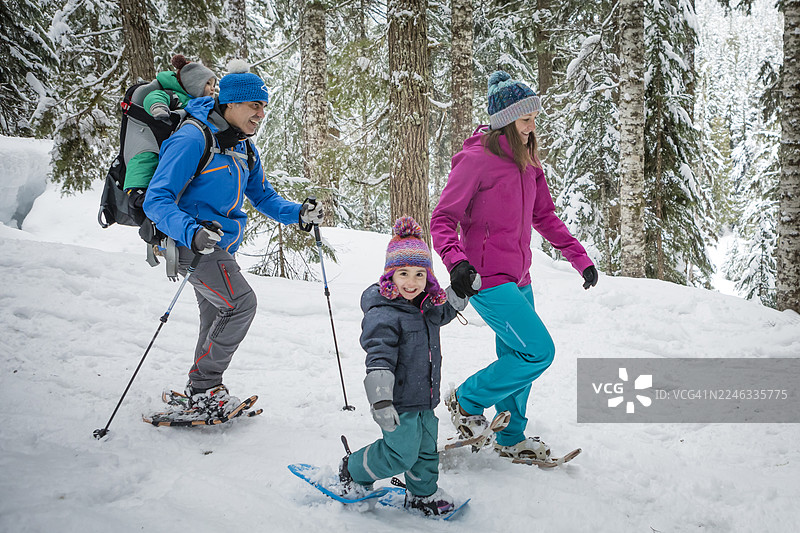 一家人在雪地里穿过森林图片素材