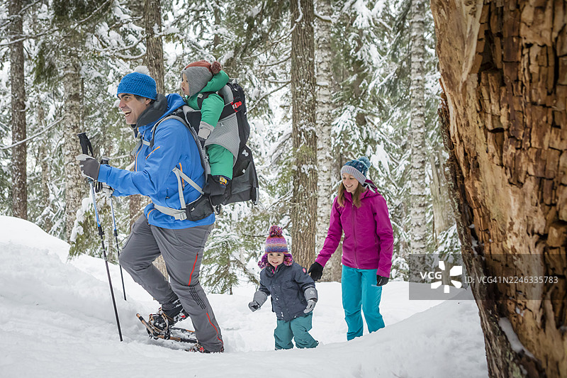 一家人在雪地里穿雪鞋穿越森林图片素材