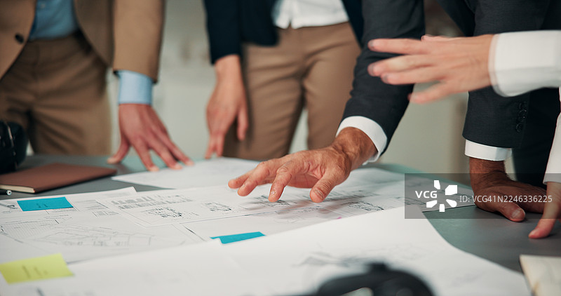 在办公室会议上，工程师、团队成员和建筑师们正在审阅、规划和讨论房地产开发项目。他们围绕着建筑蓝图，进行施工、房地产和建筑项目的相关设计。图片素材