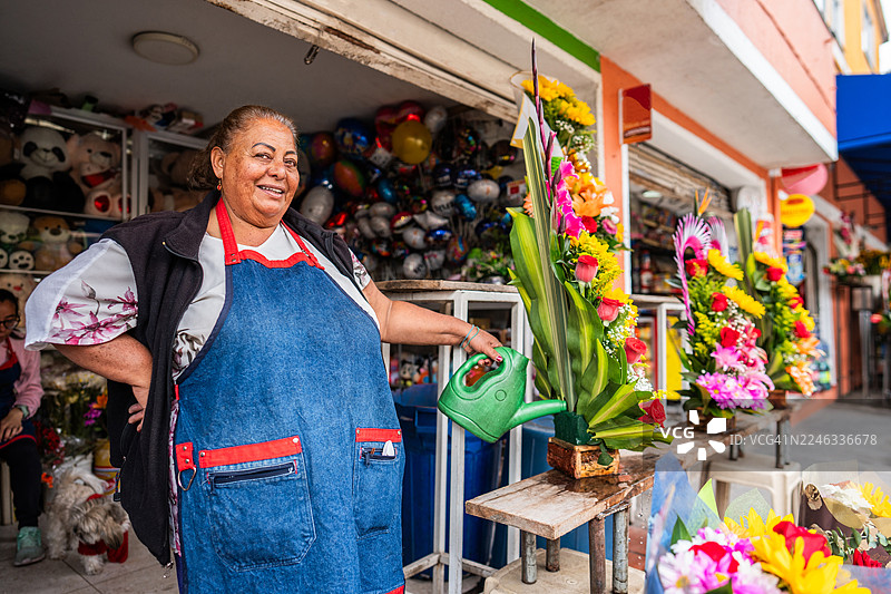 花店里，一位花艺师正在给花浇水图片素材