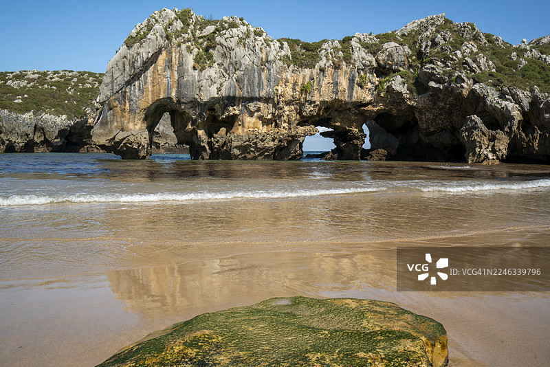 普拉亚德奎瓦斯德尔马尔，利亚内斯：石灰岩拱门和清澈海水的阳光景观图片素材
