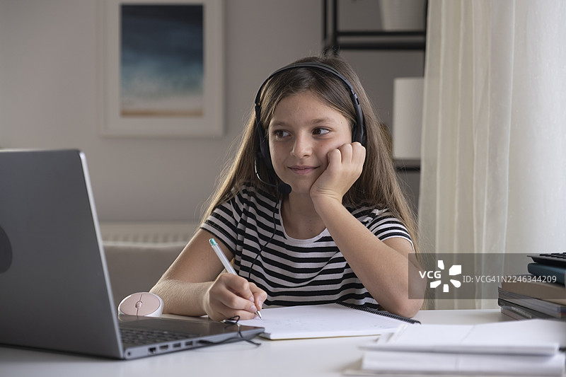 小女孩在家在线学习，在网络课程中记笔记图片素材