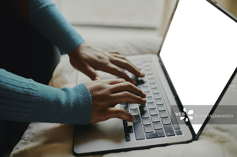 特写：手在笔记本电脑键盘上打字，屏幕空白图片素材