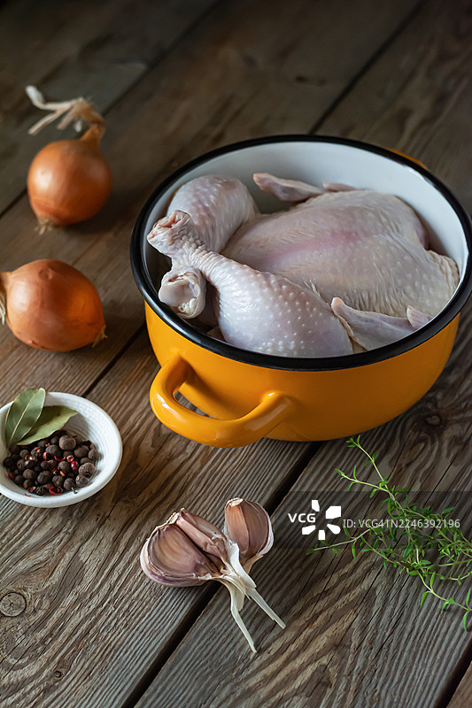 锅中炖煮的生鸡肉，在木质背景上烘烤图片素材