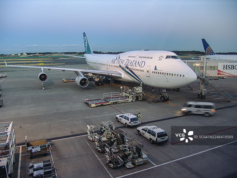 黄昏时分，新西兰航空波音 747 飞机停在机场登机口图片素材