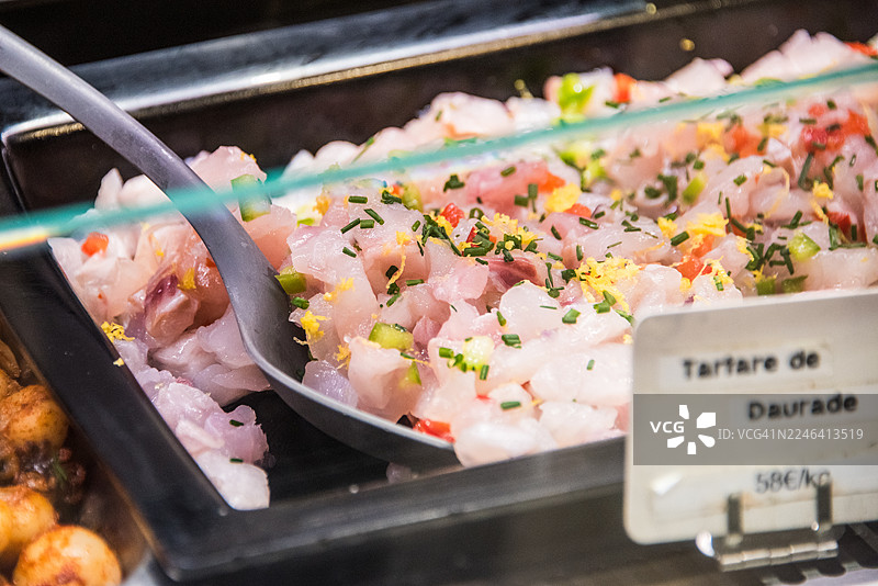 海鲷鱼鞑靼佐以服务勺摆放在鱼类柜台图片素材