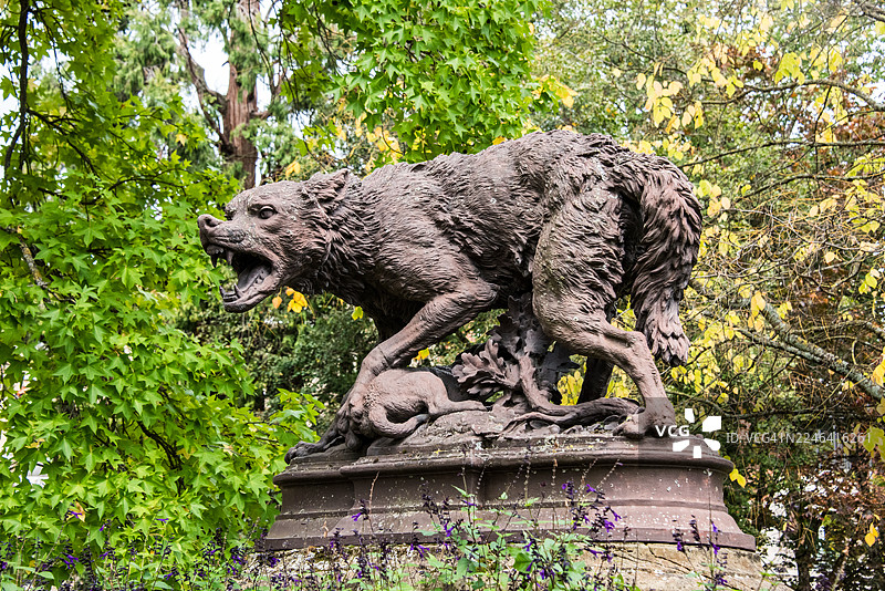 图卢兹大圆广场上，母狼叼着幼崽的雕塑面对着一群狗图片素材
