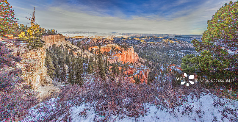 冬季,在美国布莱斯峡谷国家公园,壮观的岩层和松树覆盖着白雪皑皑的山峦,在充满活力的天空下构成令人惊叹的航拍景观。图片素材
