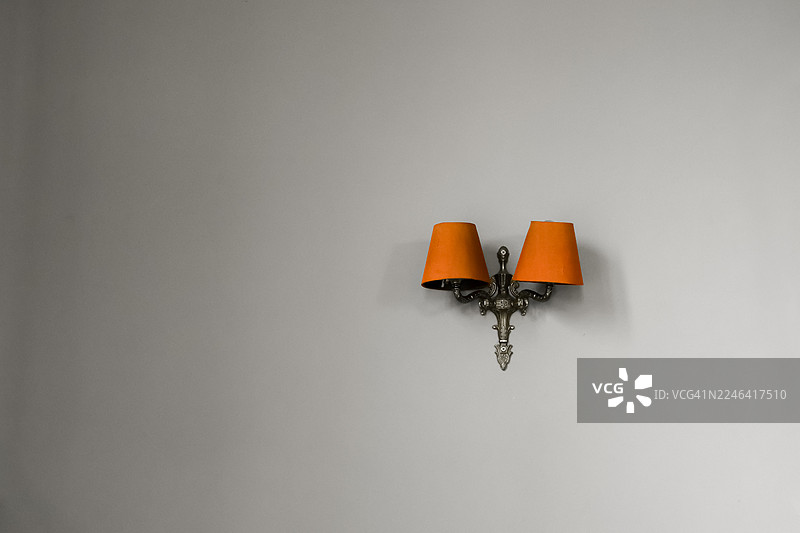 中性墙壁上饰有两盏橙色灯罩的华丽壁灯图片素材