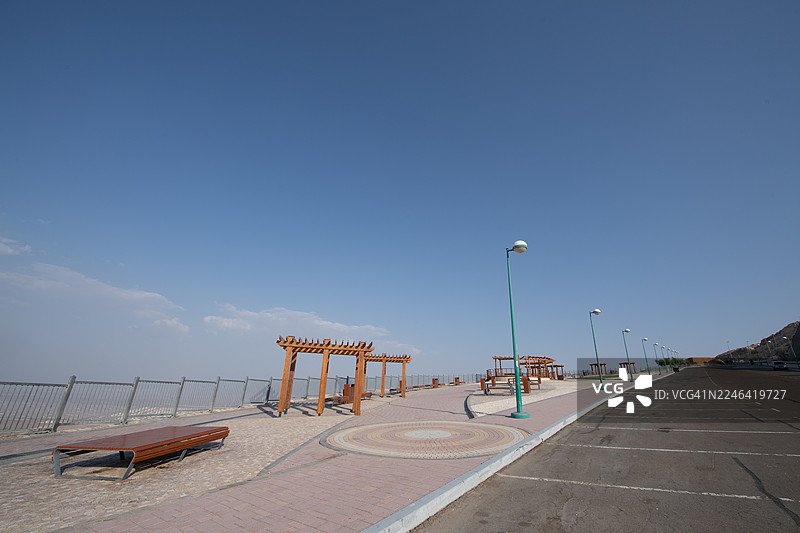晴朗蓝天下，有长椅和凉亭的空旷道路和风景优美的观景点，位于阿拉伯联合酋长国艾因的杰贝勒哈菲特。图片素材