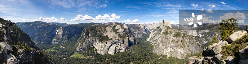 约塞米蒂山谷全景，拥有高耸的花岗岩悬崖、茂密的森林和远处的瀑布，在晴朗的蓝天下点缀着几朵云彩，地点：约塞米蒂国家公园，美国，USA，冰川点步道起点图片素材