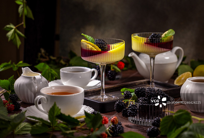 质朴桌上的美味意式奶冻配新鲜黑莓和茶图片素材