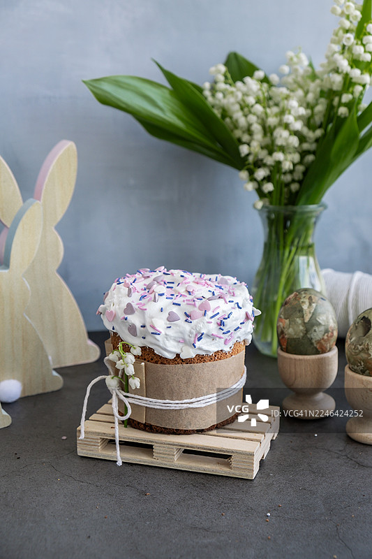 美味的复活节蛋糕，带有白色糖霜和彩色糖珠，周围是节日装饰图片素材