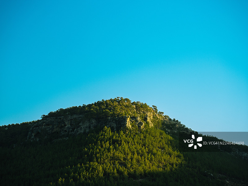 土耳其西利夫克，阳光沐浴下的苍翠山峦与蔚蓝天空的低角度视图图片素材