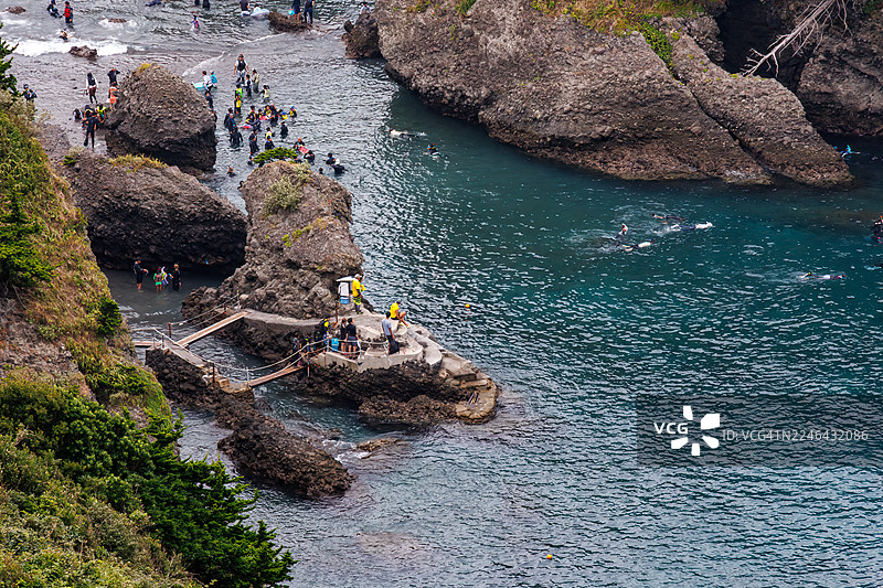 从海角天文台俯瞰的日向滩美丽蔚蓝大海。可以看到鬼岛等无人岛、小岛和当地的岩石海岸。潜水员和浮潜者乘坐渔船在海上航行。图片素材