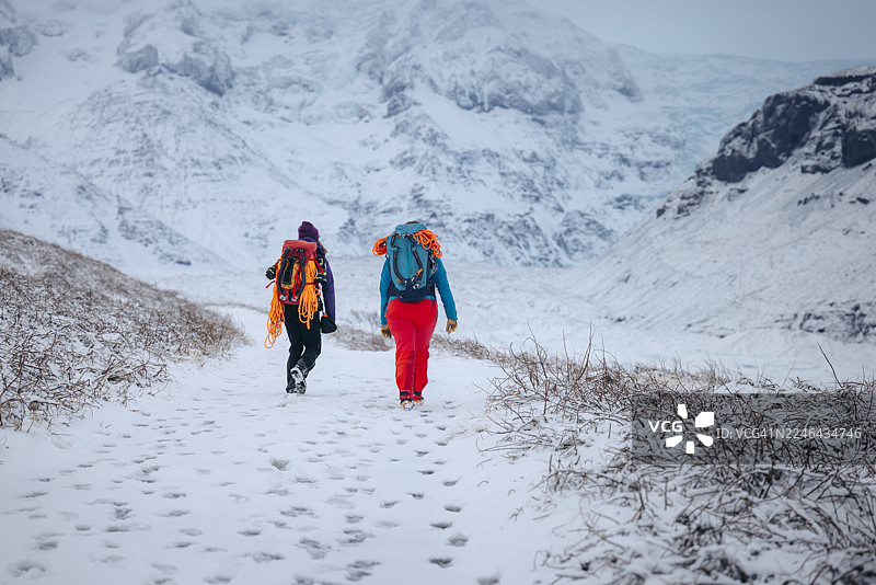 女性在雪地小径上徒步图片素材