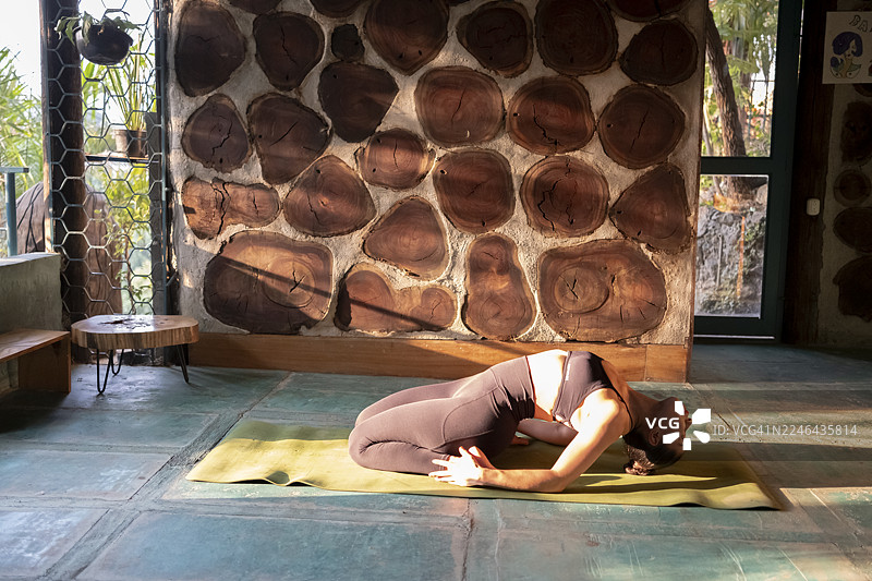 年轻女子在专门设计的空间里做瑜伽，摆出各种姿势，以达到更好的冥想和专注效果。图片素材