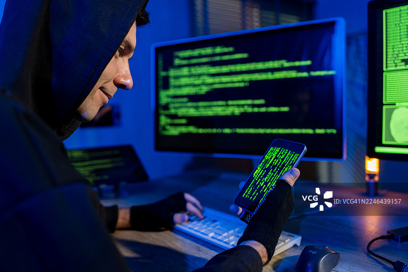 黑客使用多屏幕和智能手机工作图片素材