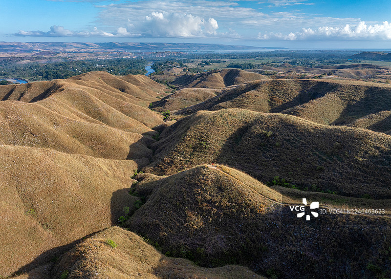 印尼苏门答腊岛独特的起伏山丘和广阔的开放式景观，在动态天空下，通过戏剧性的鸟瞰全景捕捉到。在日出时见证这个偏远而迷人的目的地的原始、狂野之美。图片素材