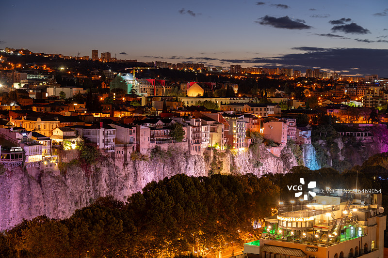 暮色下的第比利斯老城：城市灯火照亮历史建筑和库拉河。图片素材