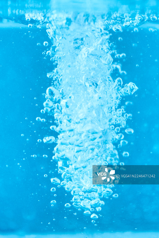 清澈水中动态、清爽的流动中上升的蓝色水下气泡图片素材