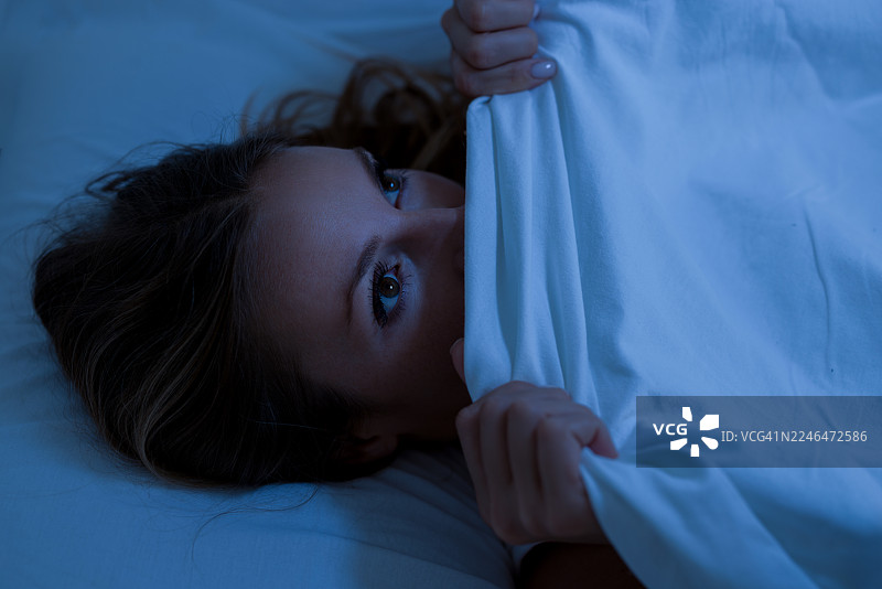 害怕的女人藏在毯子下面图片素材