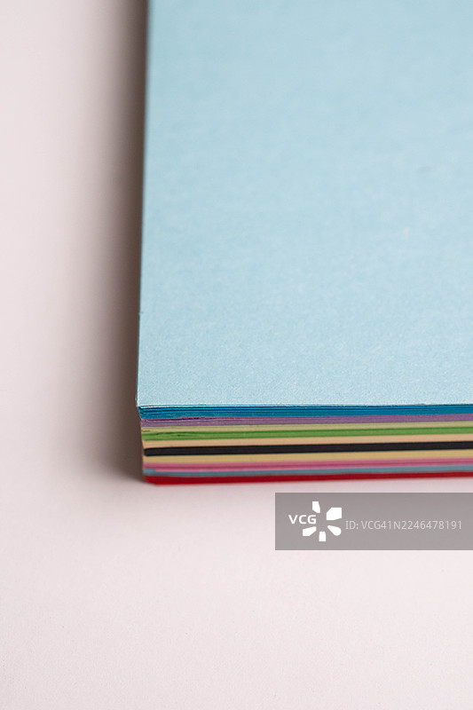 一叠整齐堆放的彩色纸张。图片素材