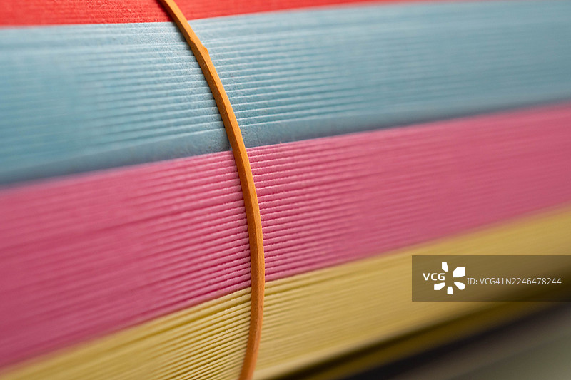 一叠整齐堆放的彩色纸张。图片素材