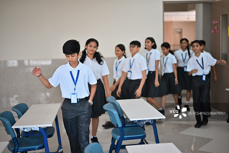 学生们在开学日开始时进入教室图片素材