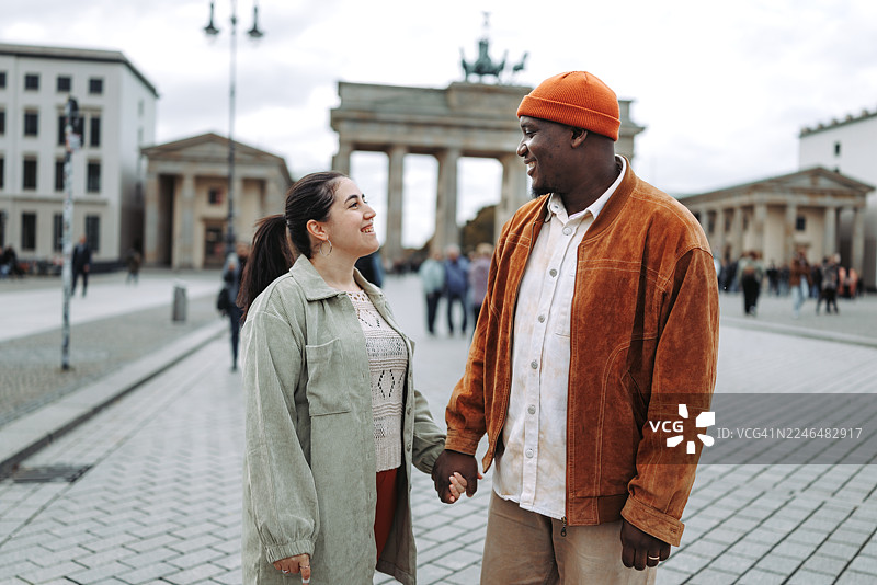 一对情侣在勃兰登堡门背景下散步图片素材