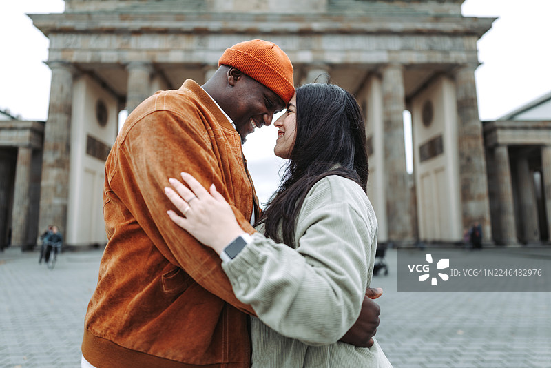 背景为勃兰登堡门的夫妇，享受着甜蜜的亲昵时刻图片素材