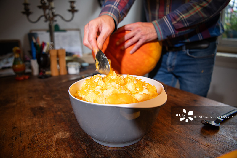 从大南瓜中挖出瓜瓤图片素材