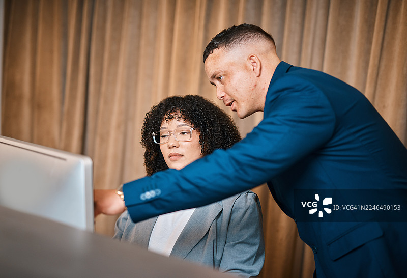 商务人士在酒店大堂的接待台旁开会，使用电脑进行协作图片素材
