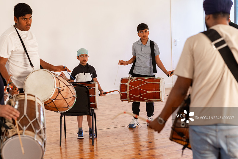 年轻音乐家学习敲击传统鼓图片素材