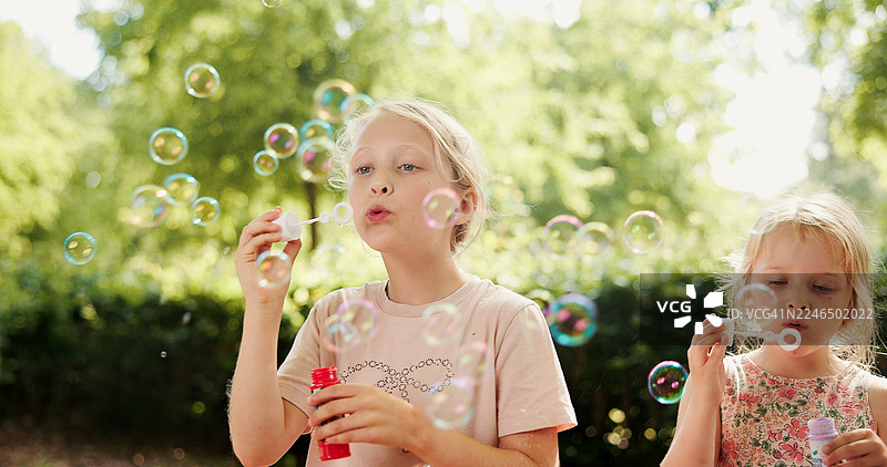 孩子们在自然中玩耍、吹泡泡，进行旅行、玩乐和亲子互动。姐妹俩在户外玩肥皂泡游戏，进行感官活动，发挥创意想象，享受假期出游。图片素材