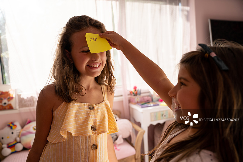 姐妹俩分享猜谜游戏的时刻图片素材
