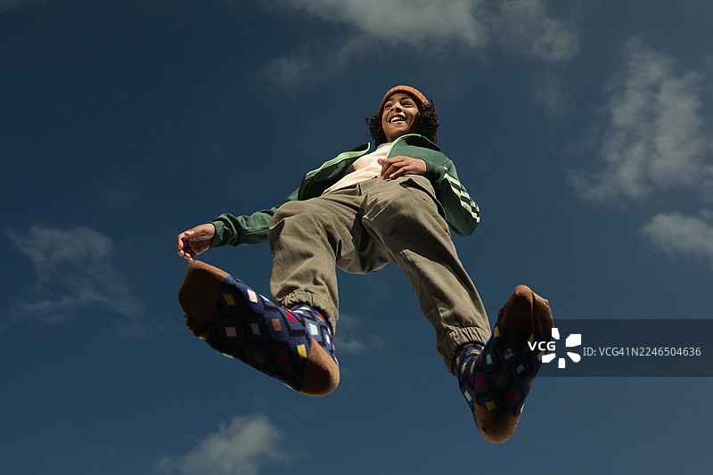 穿着休闲装的快乐男孩站在玻璃表面上图片素材