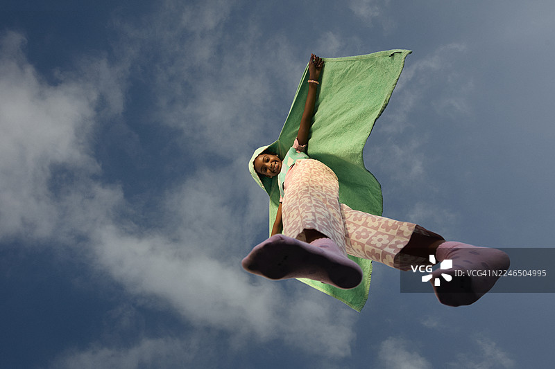 戴着披风的女孩走在玻璃上，面带微笑图片素材