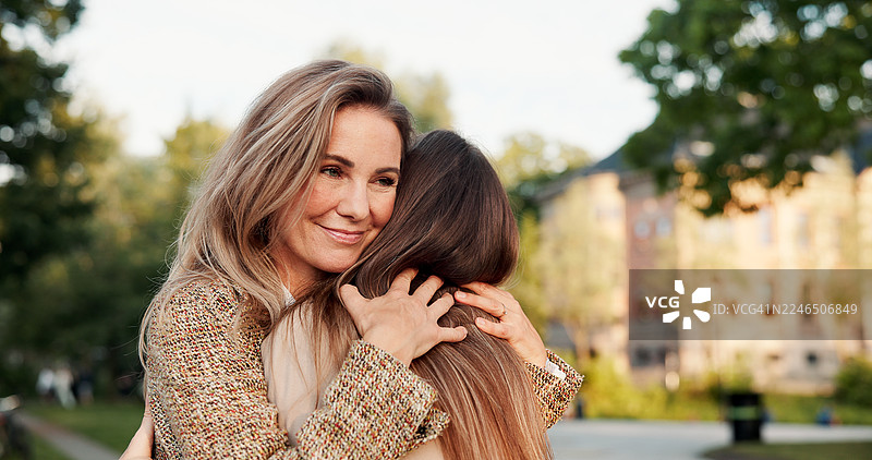 女性，微笑，朋友们在户外拥抱重逢，在假期中因爱或情谊而团结在一起，充满信任。开心的人们在城市中关怀或拥抱，以感恩的心表达连接、支持或感谢，共度假期。图片素材