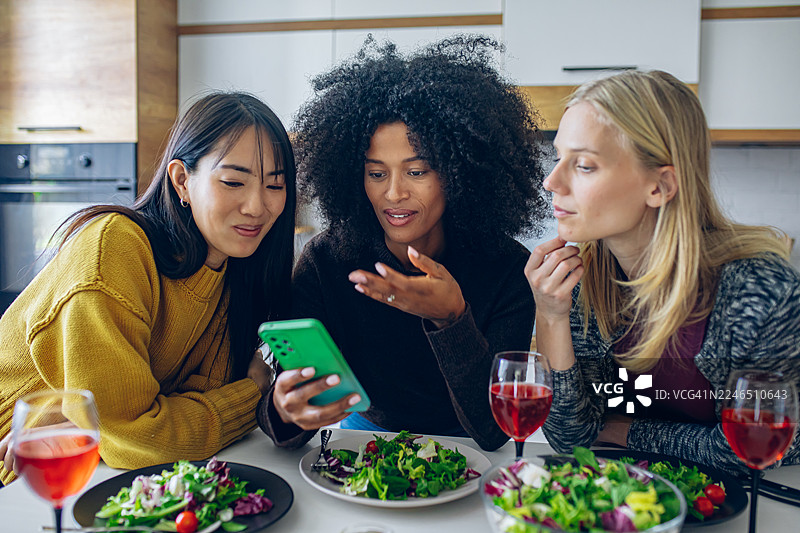 女性在厨房放松并使用智能手机图片素材